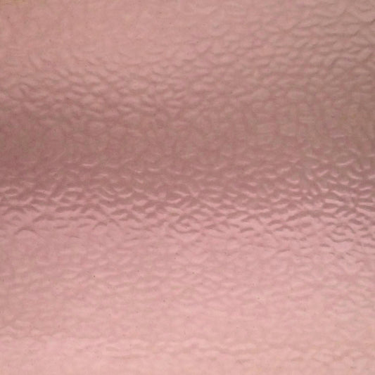 A close-up of a textured pink surface with a subtle hammered or pebbled pattern.