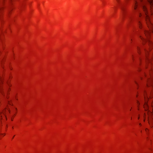 Red textured glass with a hammered or wavy pattern, filling the entire frame.